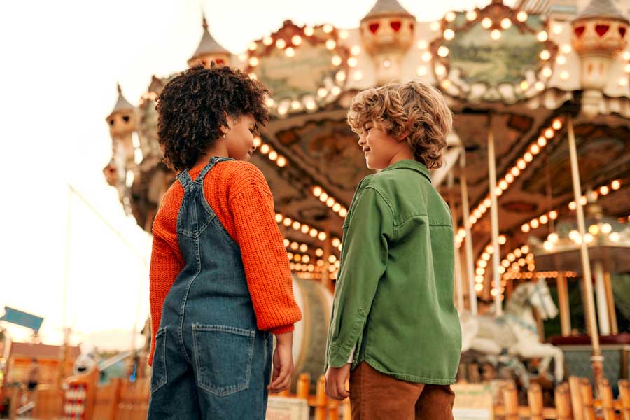 Family Fun Day with 2 kids in front of carosel at a family fun day from www.extraordinaryevents.co.uk