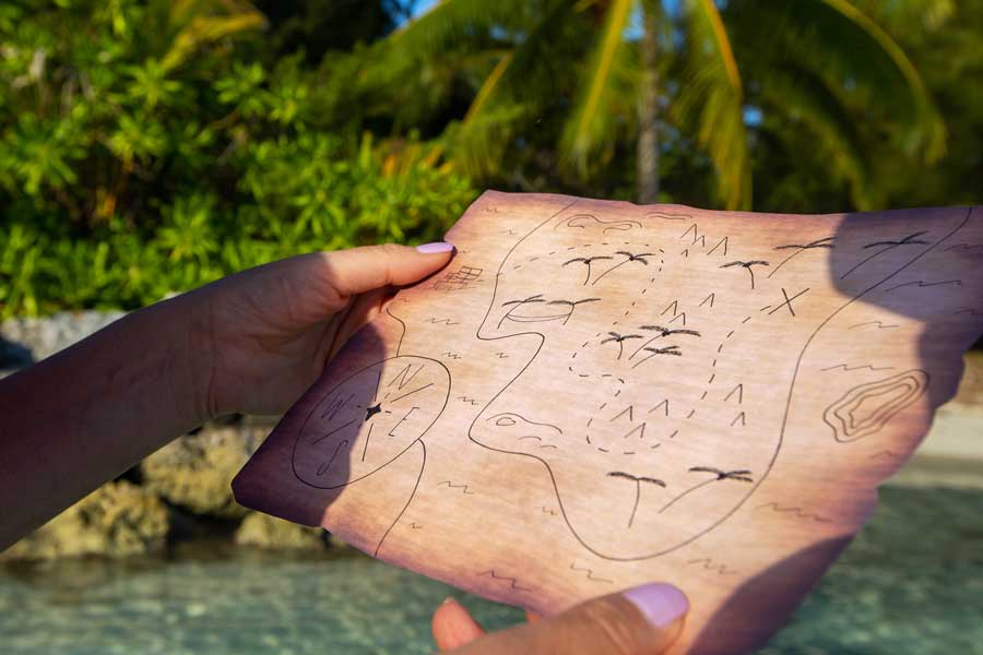 Showing person holding treasure map for treasure hunts from www.extraordinaryevents.co.uk